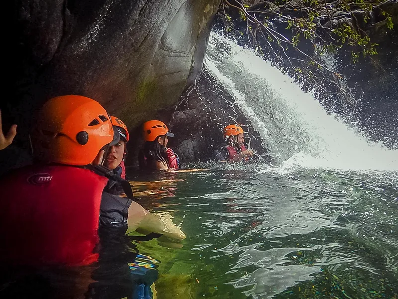 Rope swing over a crystal clear rainforest pool in El Yunque